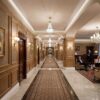 Installed New York Baseboard Molding adding a crisp architectural finish along the walls of an elegant upscale corridor interior.